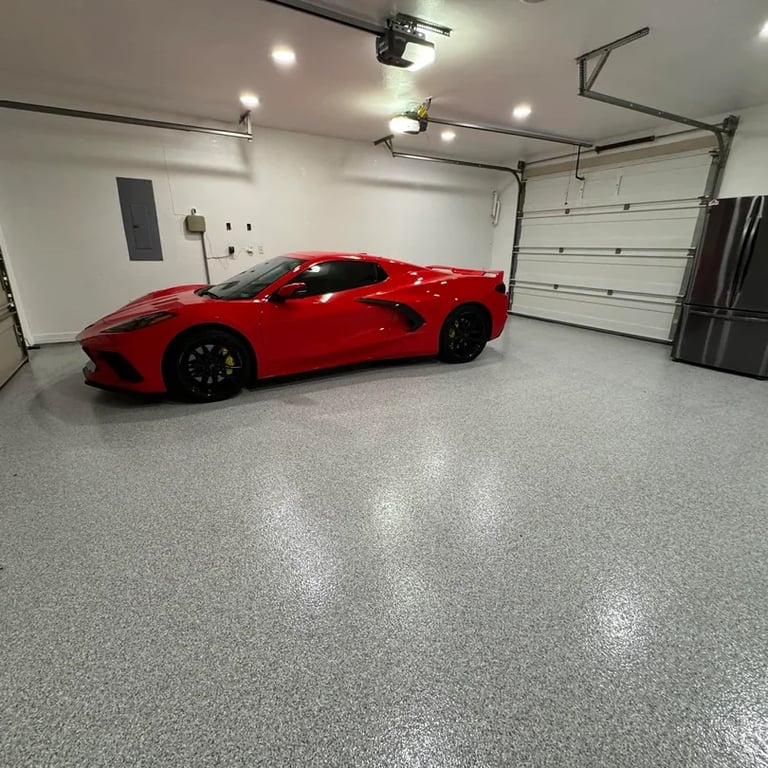 Red sports car parked in a modern well-lit garage with polished concrete flooring