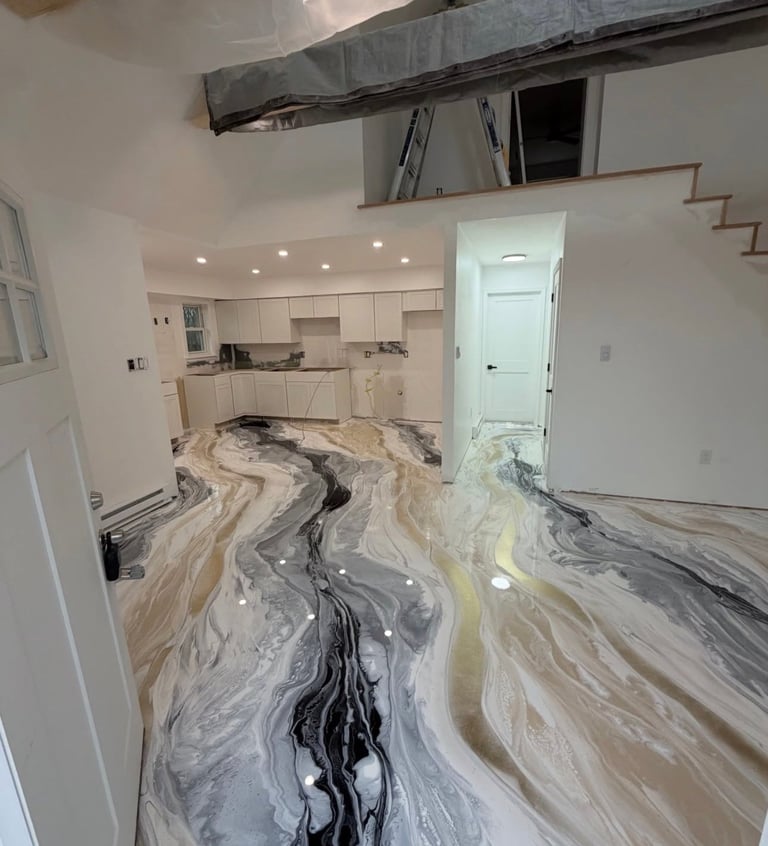 Modern kitchen renovation with marble flooring featuring black and white swirled patterns, white cabinetry, and recessed lighting under construction